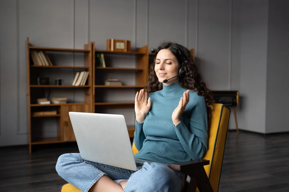 jovem trabalhadora remota conversando com cliente online e se comunicando via videochamada