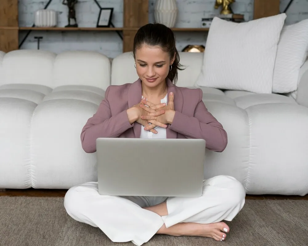 mulher sentada no chão com um laptop no colo