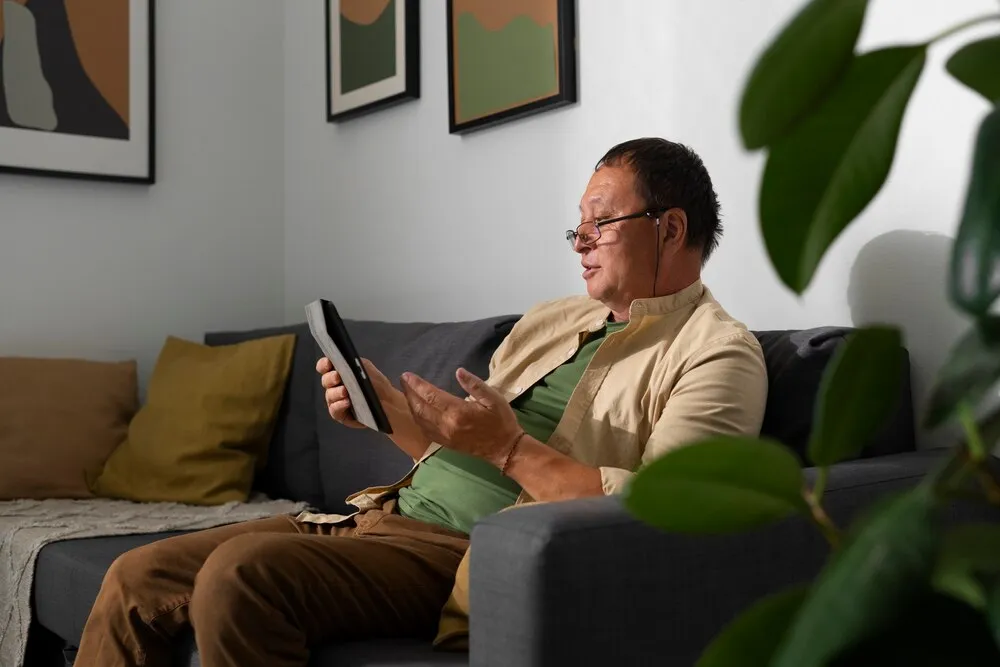 Retrato de homem idoso usando tablet em casa