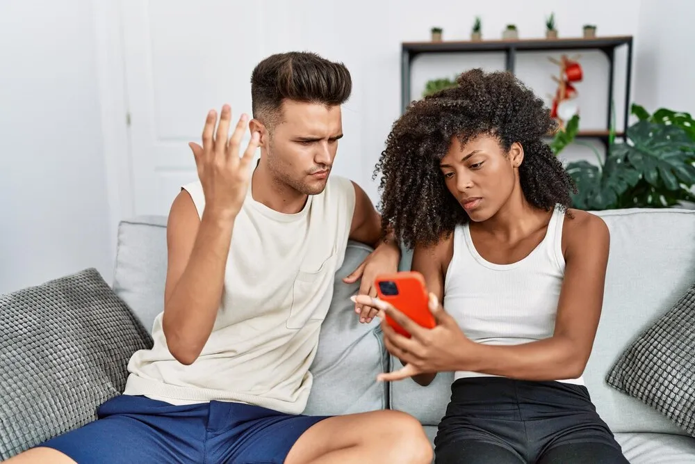casal de homem e mulher com problemas usando smartphone em casa