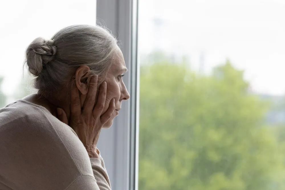 senhora idosa solitária e perturbada olhando pela janela com desespero e frustração, passando por depressão, apatia, transtorno mental, refletindo sobre problemas de saúde, preocupada com a perda de memória e demência