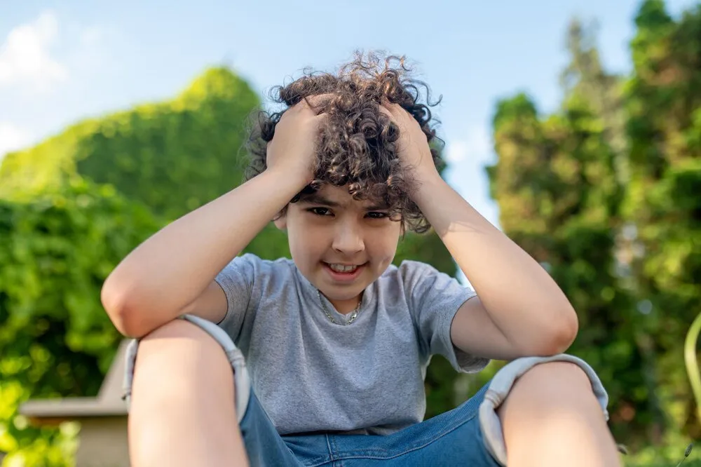 dilema o menino leva as mãos perto da cabeça e pensa sobre algo