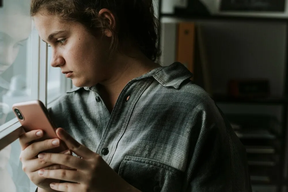 garota adolescente sofrendo bullying pelas redes sociais